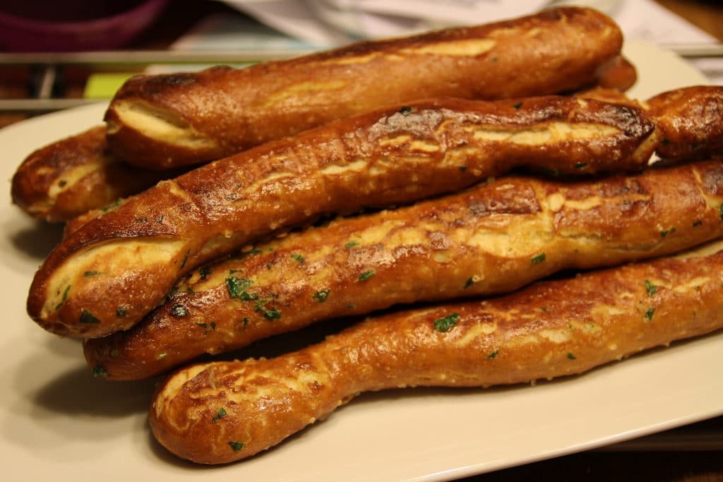 Baked Soft Pretzel Sticks - Soft, tender, buttery and brushed with a garlic and herb butter... these soft pretzel sticks from scratch taste amazingly good!