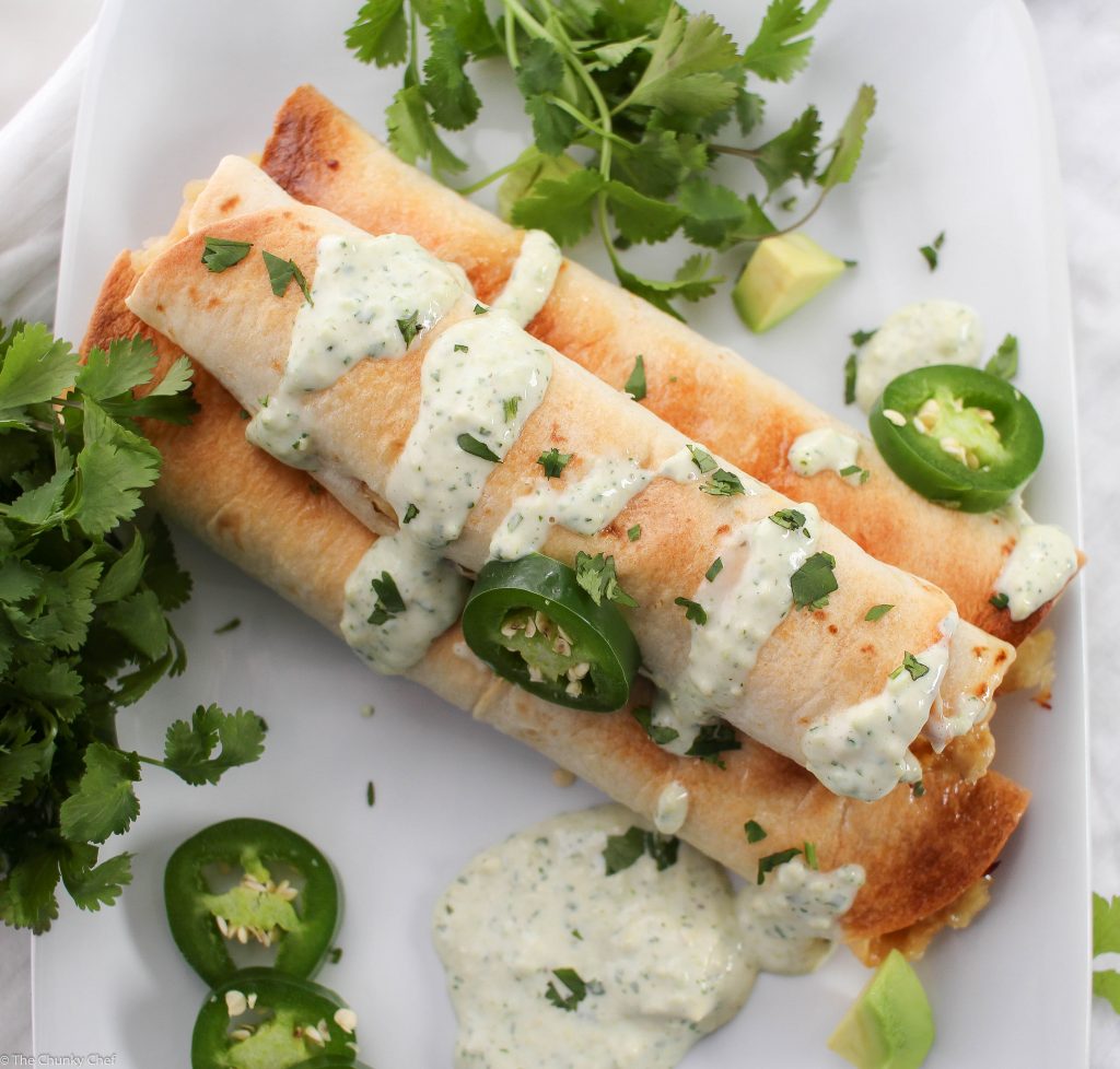 Cheesy Chicken Jalapeno Popper Taquitos - All the flavors of a cheesy jalapeno popper mixed with chicken and rolled up into crispy baked taquitos... and the filling is cooked in the slow cooker!