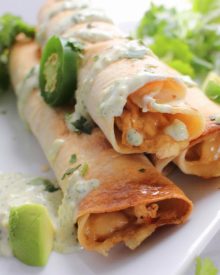 Cheesy Chicken Jalapeno Popper Taquitos - All the flavors of a cheesy jalapeno popper mixed with chicken and rolled up into crispy baked taquitos... and the filling is cooked in the slow cooker!