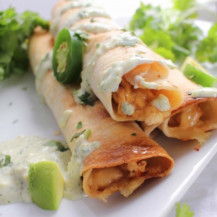 Cheesy Chicken Jalapeno Popper Taquitos - All the flavors of a cheesy jalapeno popper mixed with chicken and rolled up into crispy baked taquitos... and the filling is cooked in the slow cooker!