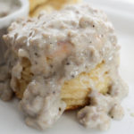 Soft and fluffy buttermilk biscuits, perfectly big yet light at the same time, smothered with a creamy homemade sausage gravy... classic down home cooking!