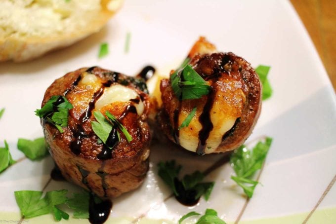 Italian stuffed flank steak medallions on plate with drizzle of balsamic glaze