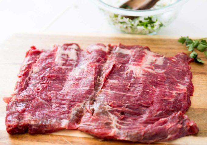 Butterflied flank steak on cutting board