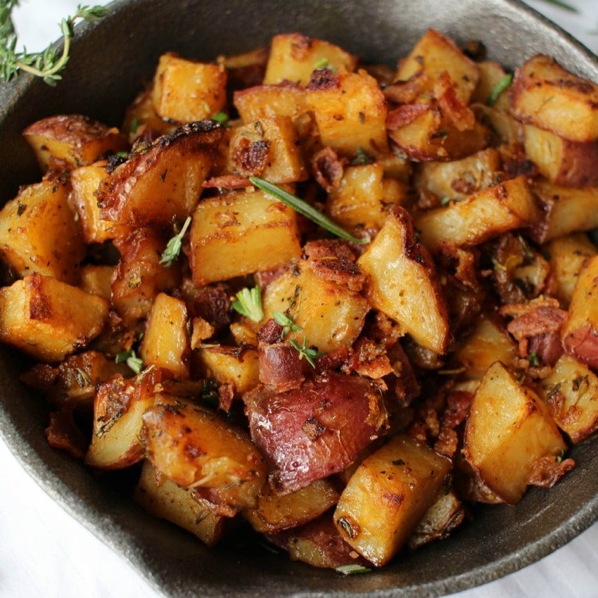 Perfectly seasoned and roasted potatoes topped with caramelized onions, bacon pieces and fresh herbs. The perfect side dish for breakfast!