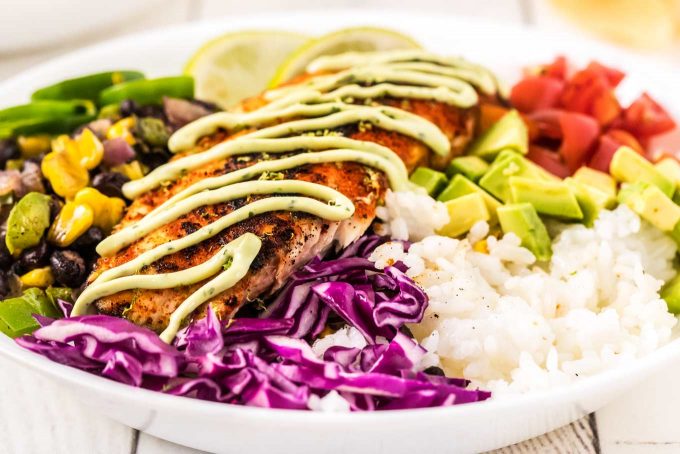 These fresh and healthy fish taco bowls are filled with blackened white fish, corn and black bean salsa, and topped with cilantro avocado crema!  On the table in about 30 minutes for a quick and easy dinner idea! #fishtacos #fish #tacos #blackened #bowls #mexican #dinner #healthyrecipe #healthy #seafood