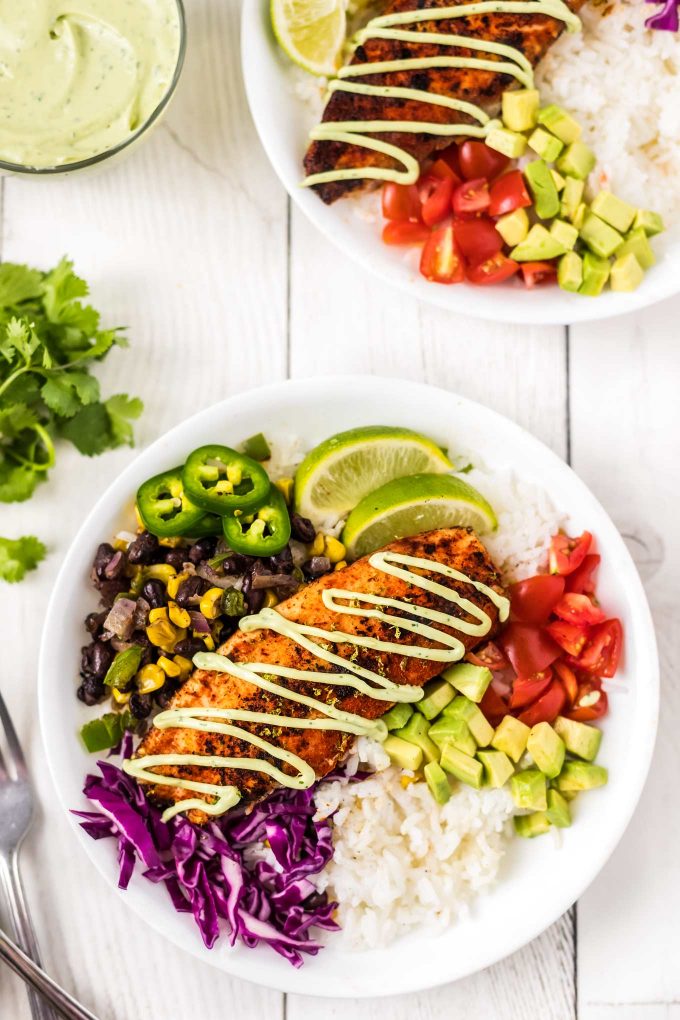 These fresh and healthy fish taco bowls are filled with blackened white fish, corn and black bean salsa, and topped with cilantro avocado crema!  On the table in about 30 minutes for a quick and easy dinner idea! #fishtacos #fish #tacos #blackened #bowls #mexican #dinner #healthyrecipe #healthy #seafood