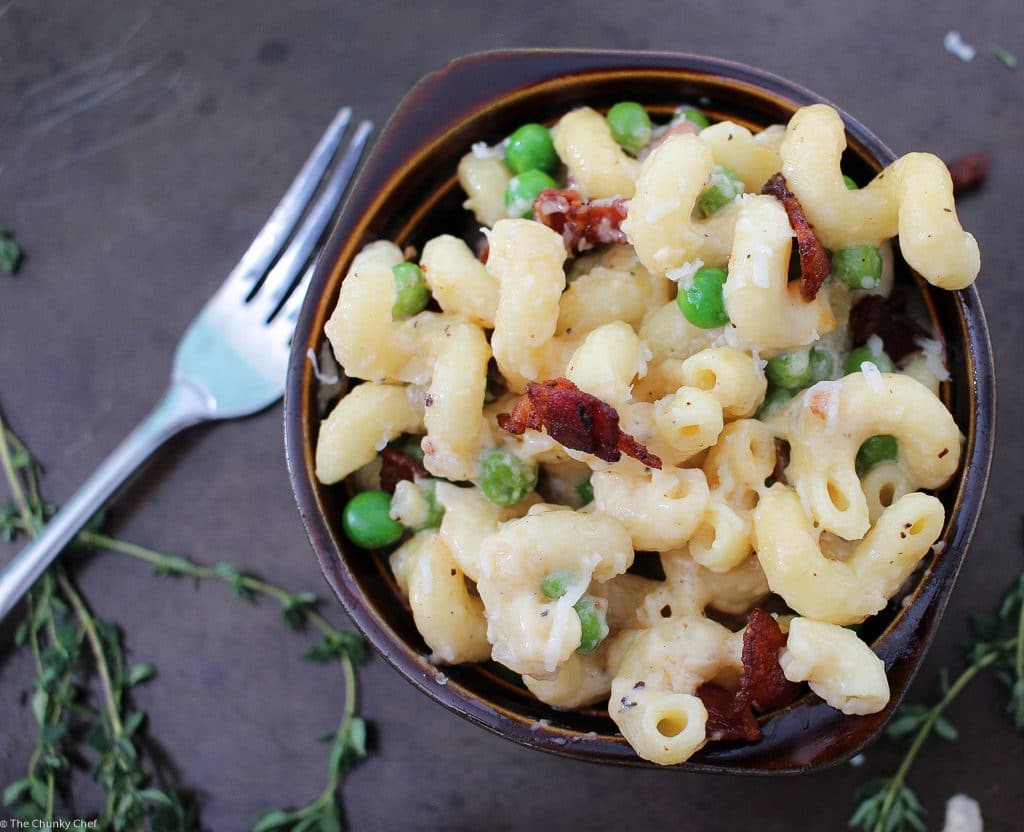 Rich and creamy macaroni and cheese gets lightened up a bit and tossed with sweet peas, crispy bacon and flavorful caramelized onions!