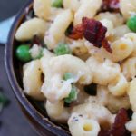 Rich and creamy macaroni and cheese gets lightened up a bit and tossed with sweet peas, crispy bacon and flavorful caramelized onions!