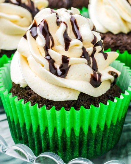 Moist and rich chocolate cupcakes baked with Guinness beer, topped with a silky Irish cream frosting, and drizzled with an Irish cream chocolate sauce! #chocolate #cupcakes #stpatricksday #stpattysday #baking #dessertrecipe #guinness #irishcream