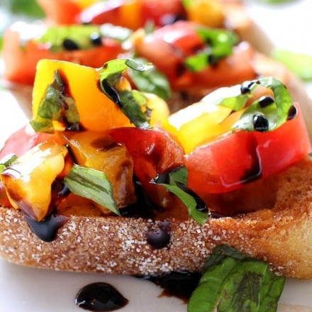 The Chunky Chef | Classic bruschetta gets a gourmet twist by using sweet heirloom tomatoes, basil, fresh mozzarella, and drizzled with a decadent balsamic reduction glaze!