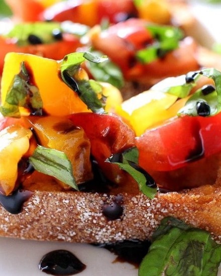 The Chunky Chef | Classic bruschetta gets a gourmet twist by using sweet heirloom tomatoes, basil, fresh mozzarella, and drizzled with a decadent balsamic reduction glaze!