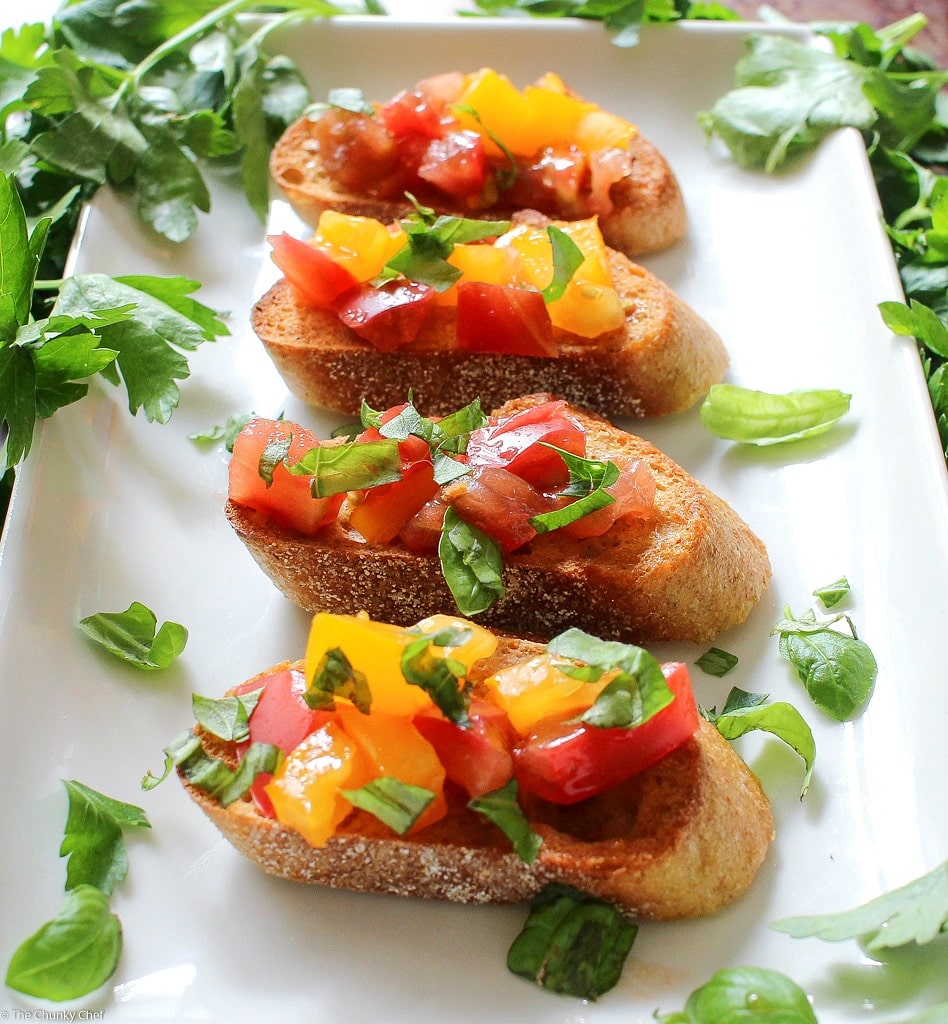 The Chunky Chef | A recipe for classic bruschetta gets a gourmet twist by using sweet heirloom tomatoes, basil, fresh mozzarella, and drizzled with a decadent balsamic reduction glaze!