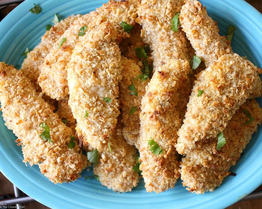 Not your run of the mill baked chicken tenders... this chicken is crusted in a delicious coconut and cashew breading and baked to golden brown perfection!