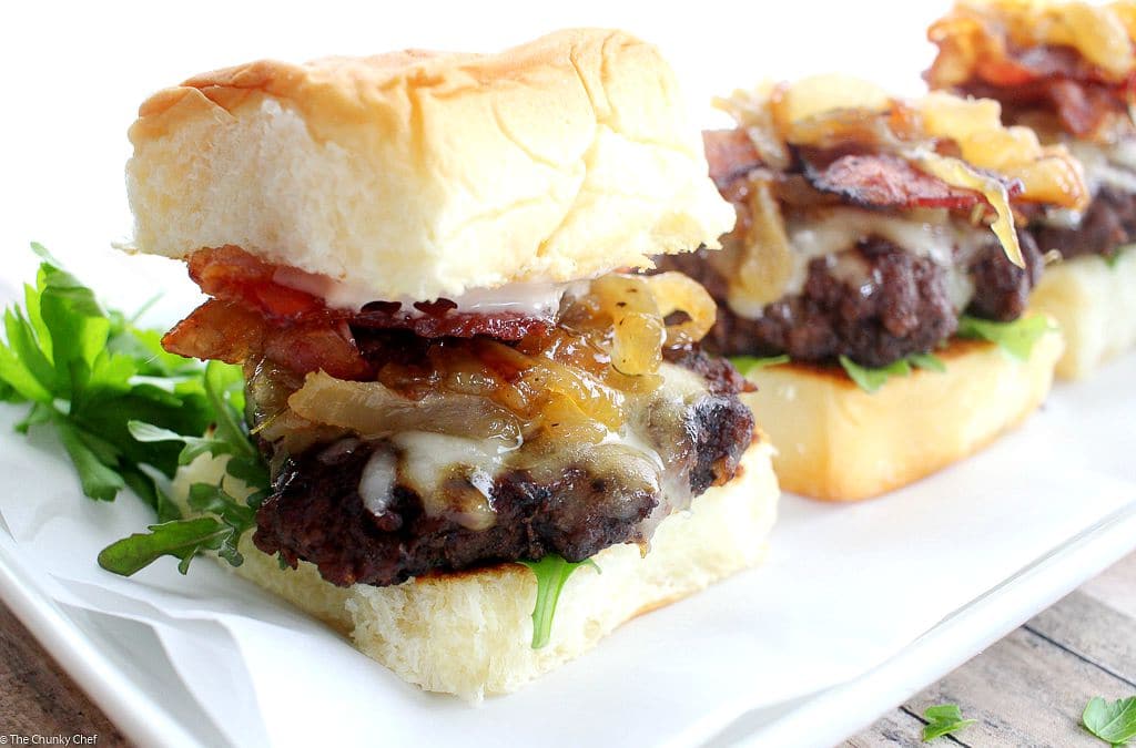 Caramelized Onion Beef Sliders | The Chunky Chef | Ground beef sliders smothered in melted gruyere cheese, topped with caramelized onions and thyme, peppered bacon and a flavorful A1 mayo!