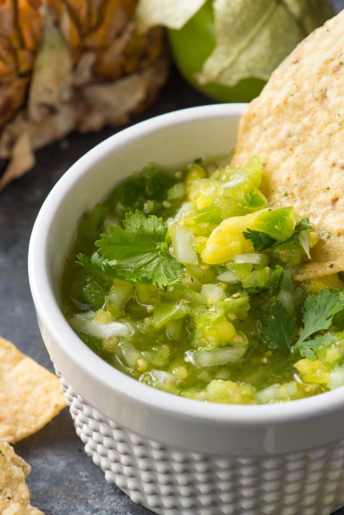 Tortilla chip scooping tomatillo salsa