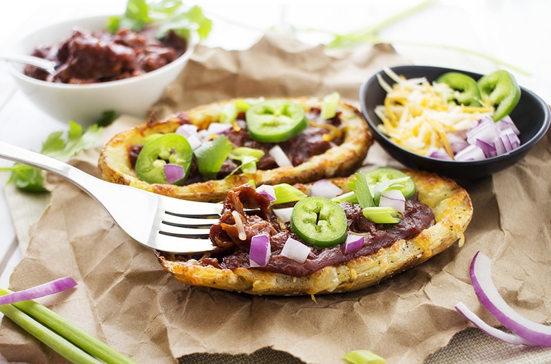 Loaded Beef BBQ Potato Skins | The Chunky Chef | The classic potato skins appetizer gets a BBQ twist! Savory beef BBQ on top of crispy and cheesy potato skins - perfect for game day or a great snack!