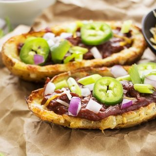 Loaded Beef BBQ Potato Skins | The Chunky Chef | The classic potato skins appetizer gets a BBQ twist! Chipotle beef BBQ on top of crispy and cheesy potato skins - perfect for game day or a great snack!