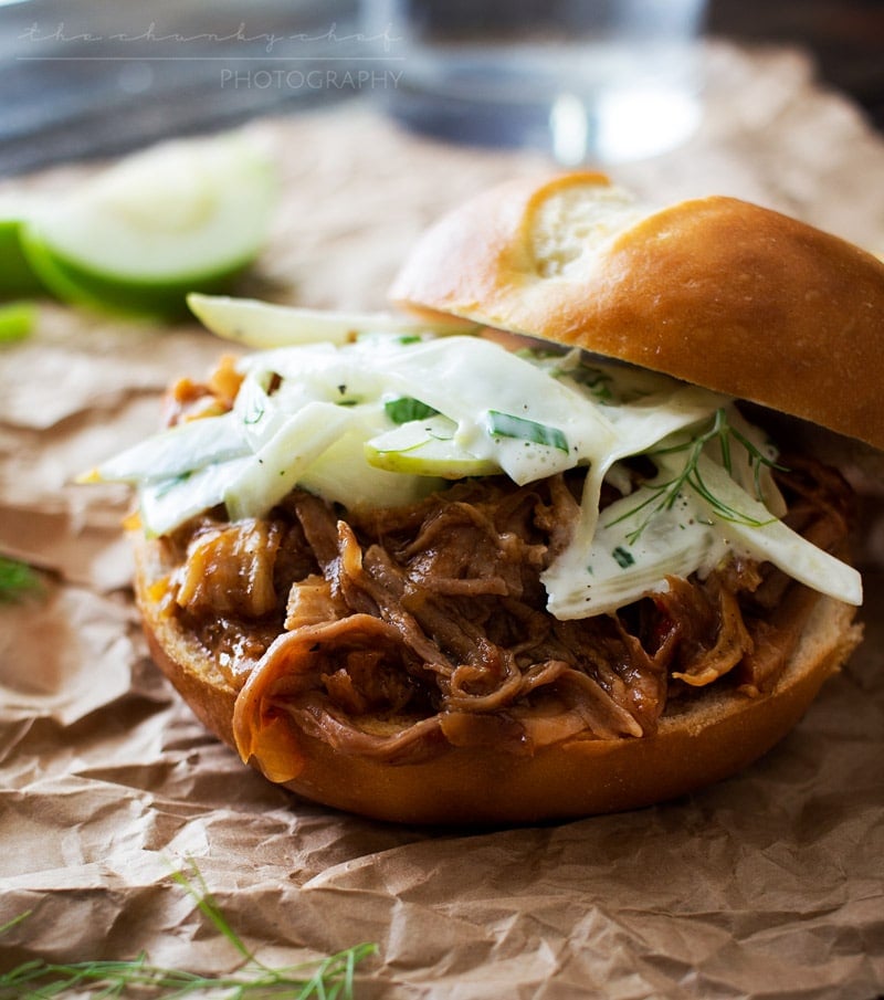Apple Bourbon Pulled Pork Sandwiches | The Chunky Chef | Soft pretzel buns filled with tender, juicy apple bourbon pulled pork and topped with a refreshing apple fennel slaw. The King of pulled pork sandwiches!