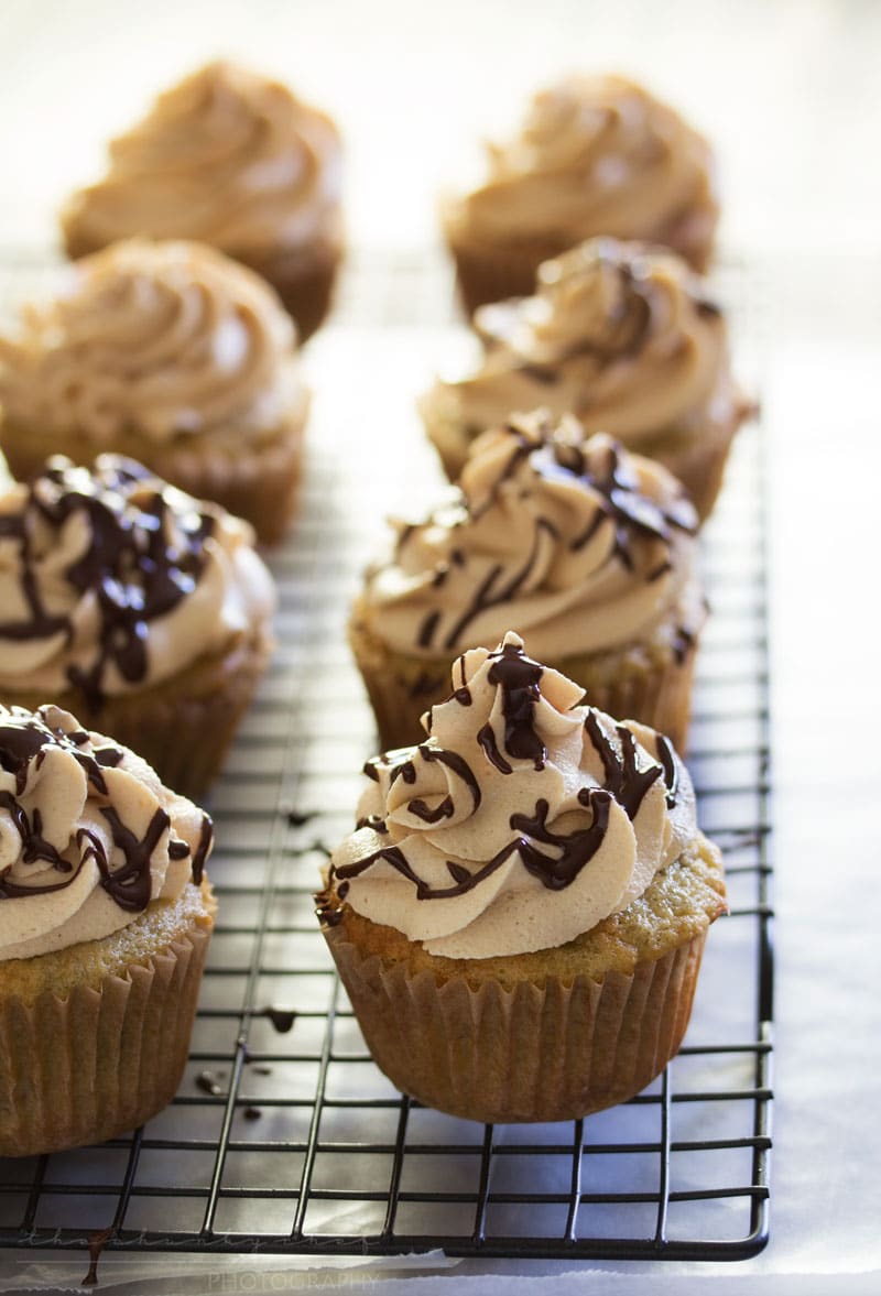 Banana Cupcakes | Unbelievably soft banana cupcakes are frosted with a creamy peanut butter cream cheese frosting that's kissed with honey, and drizzled with chocolate!