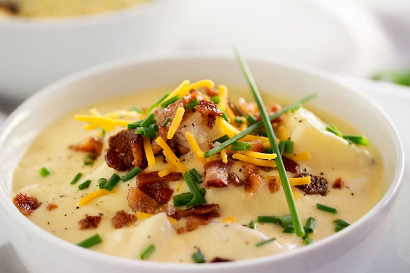 Copycat Loaded Baked Potato Soup | Creamy and thick, this potato soup is topped with savory cheese, fresh chives and crumbled bacon. It tastes just like O'Charley's loaded baked potato soup!