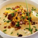 Copycat Loaded Baked Potato Soup | Creamy and thick, this potato soup is topped with savory cheese, fresh chives and crumbled bacon. It tastes just like O'Charley's loaded baked potato soup!