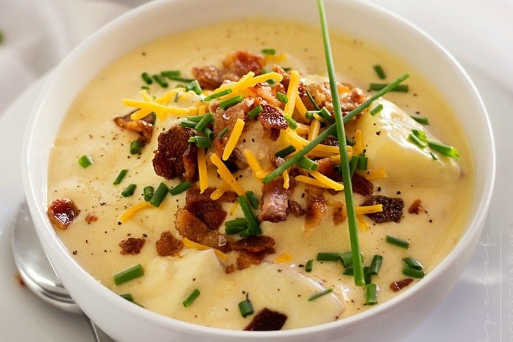 Copycat Loaded Baked Potato Soup | Creamy and thick, this potato soup is topped with savory cheese, fresh chives and crumbled bacon. It tastes just like O'Charley's loaded baked potato soup!