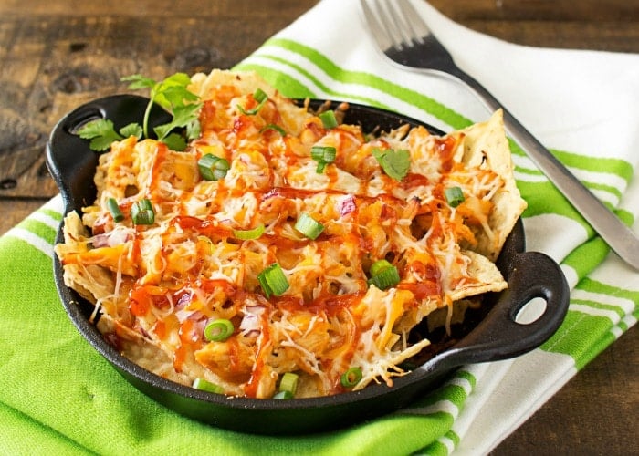 Oven Baked BBQ Chicken Pizza Nachos | Oven baked BBQ chicken pizza nachos... the awesome combination of homemade bbq sauce, juicy chicken, gooey cheese and tons of toppings! | http://thechunkychef.com