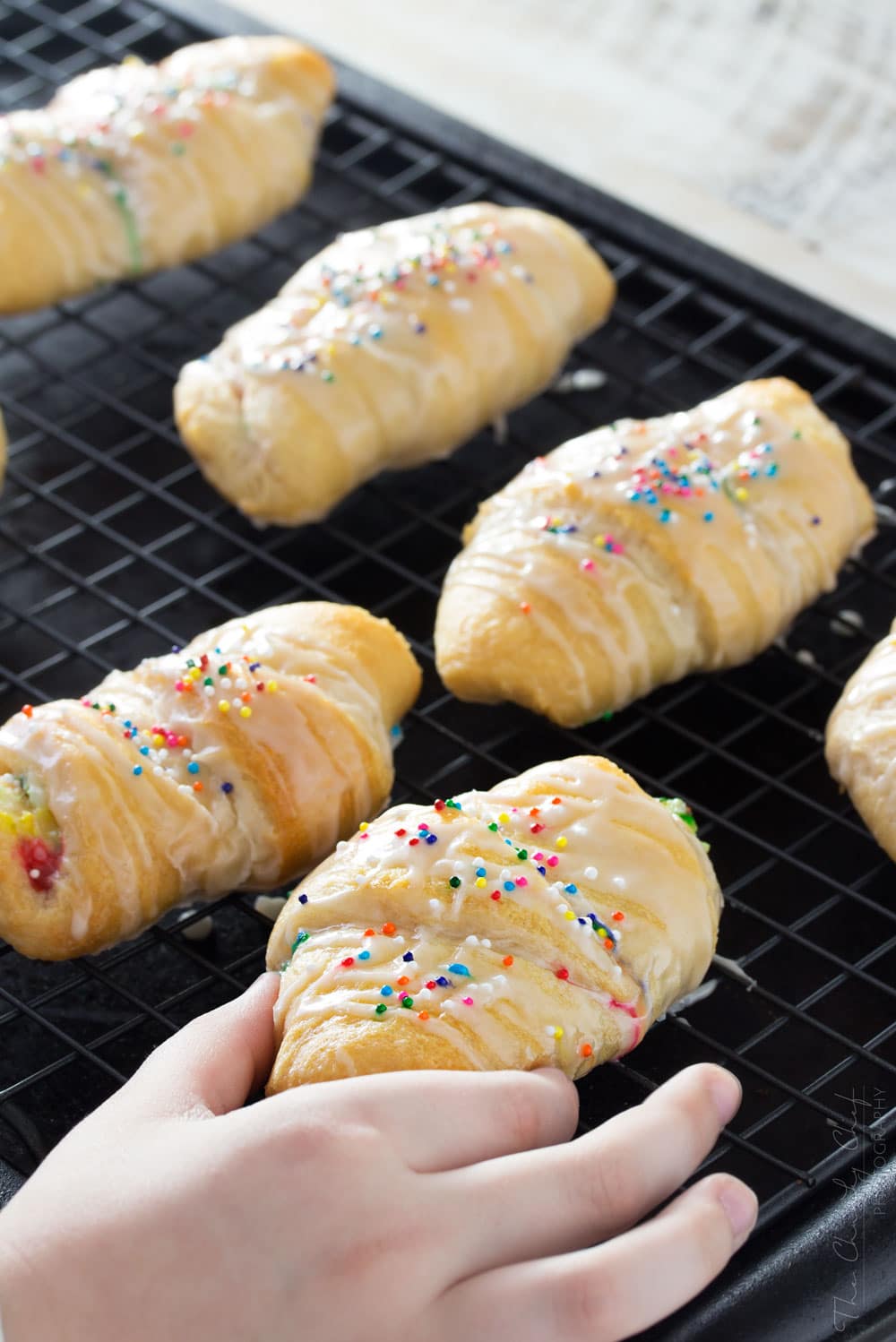 Funfetti-Cheesecake-Stuffed-Crescent-Rolls - Buttery crescent rolls are filled with an easy funfetti cheesecake spread, baked until golden, and drizzled with a vanilla glaze!! Perfect for kids! | http://thechunkychef.com