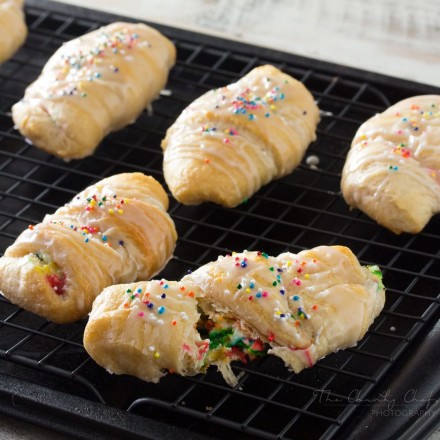 Funfetti-Cheesecake-Stuffed-Crescent-Rolls - Buttery crescent rolls are filled with an easy funfetti cheesecake spread, baked until golden, and drizzled with a vanilla glaze!! Perfect for kids! | http://thechunkychef.com