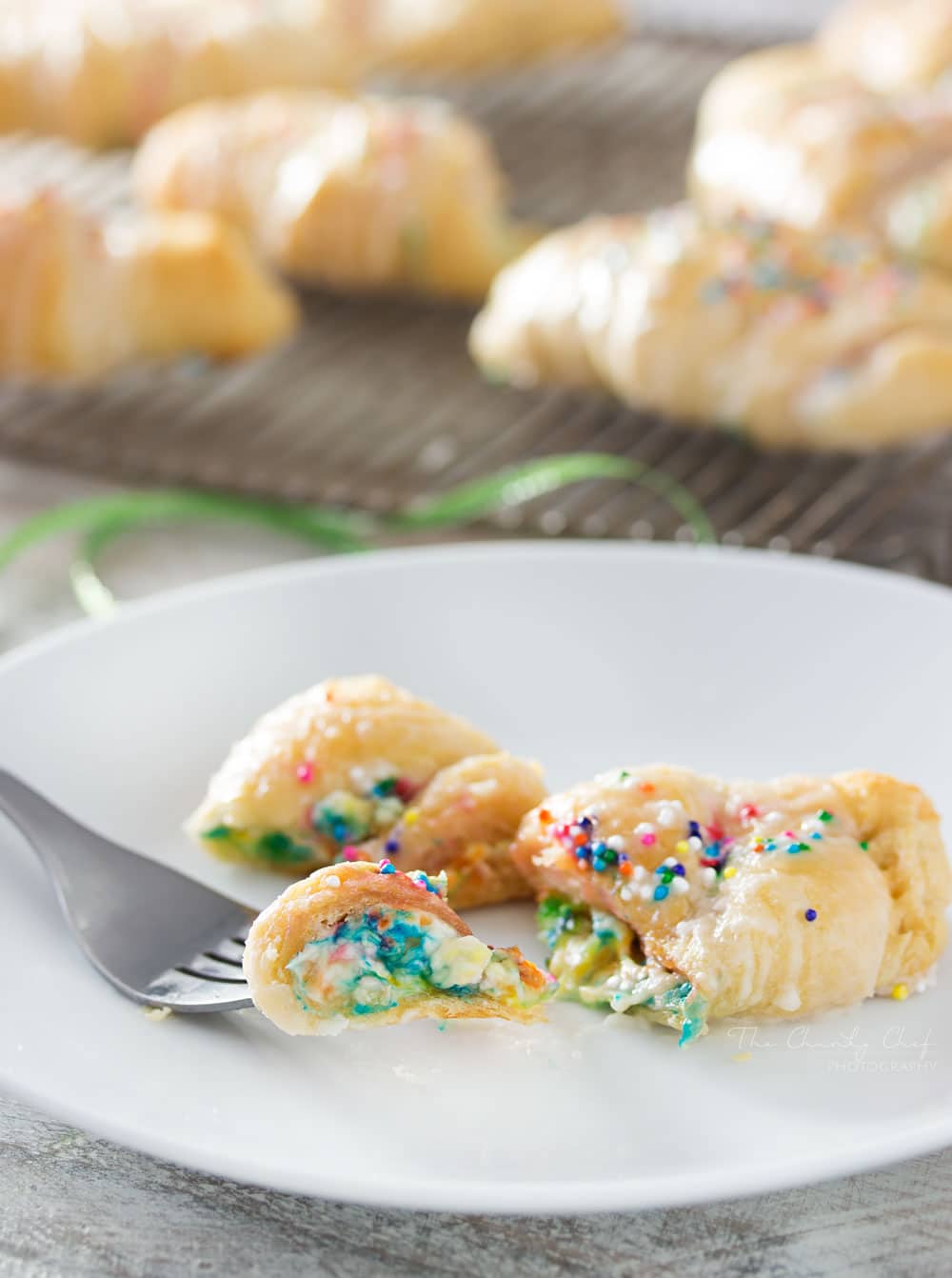 Funfetti-Cheesecake-Stuffed-Crescent-Rolls - Buttery crescent rolls are filled with an easy funfetti cheesecake spread, baked until golden, and drizzled with a vanilla glaze!! Perfect for kids! | http://thechunkychef.com