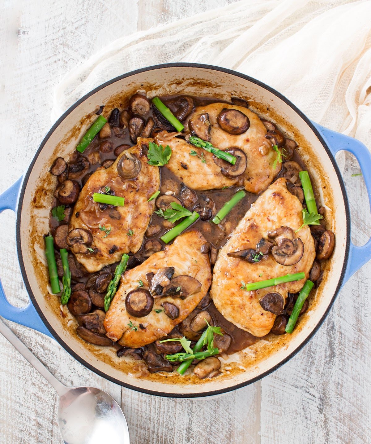 Chicken marsala in skillet with asparagus