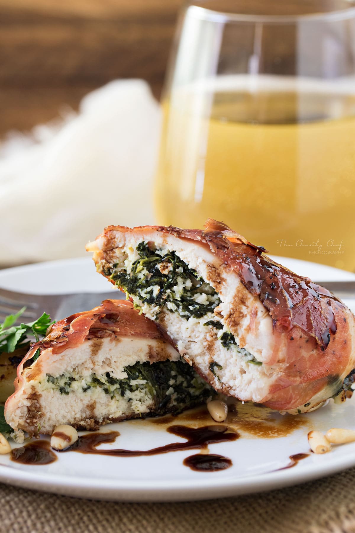 Florentine Stuffed Chicken | This Florentine stuffed chicken is filled with a deliciously cheesy spinach mixture, and toasted pine nuts, then wrapped in prosciutto and baked! | http://thechunkychef.com