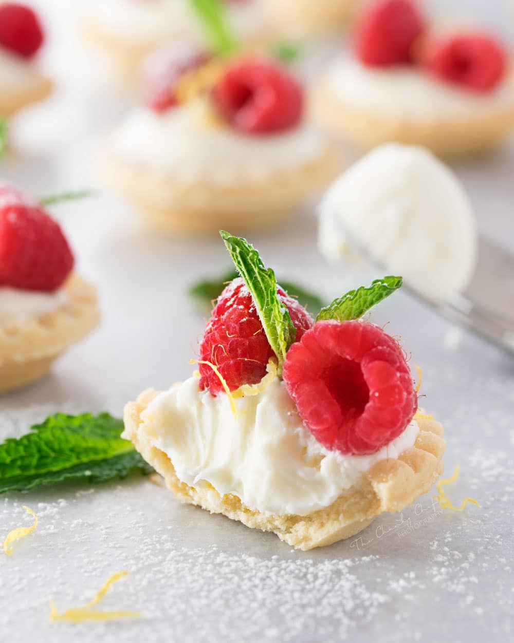 Mini No Bake White Chocolate Lemon Cheesecake Tarts | Creamy no bake white chocolate lemon cheesecake tarts, topped with your favorite fresh fruit, mint, and a dusting of powdered sugar. Impressive and easy! | http://thechunkychef.com