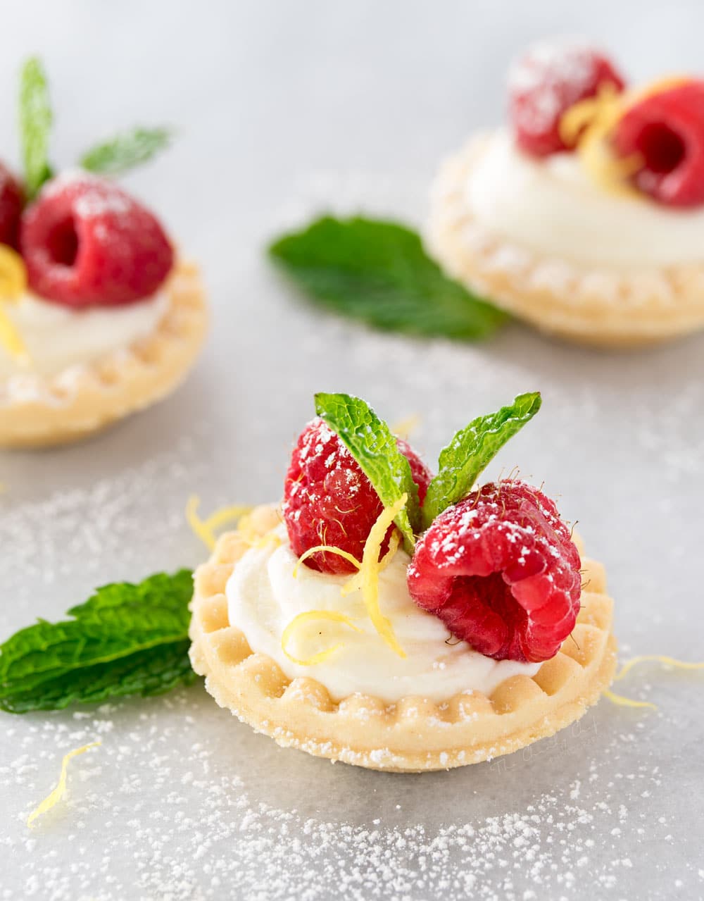 Mini No Bake White Chocolate Lemon Cheesecake Tarts | Creamy no bake white chocolate lemon cheesecake tarts, topped with your favorite fresh fruit, mint, and a dusting of powdered sugar. Impressive and easy! | http://thechunkychef.com