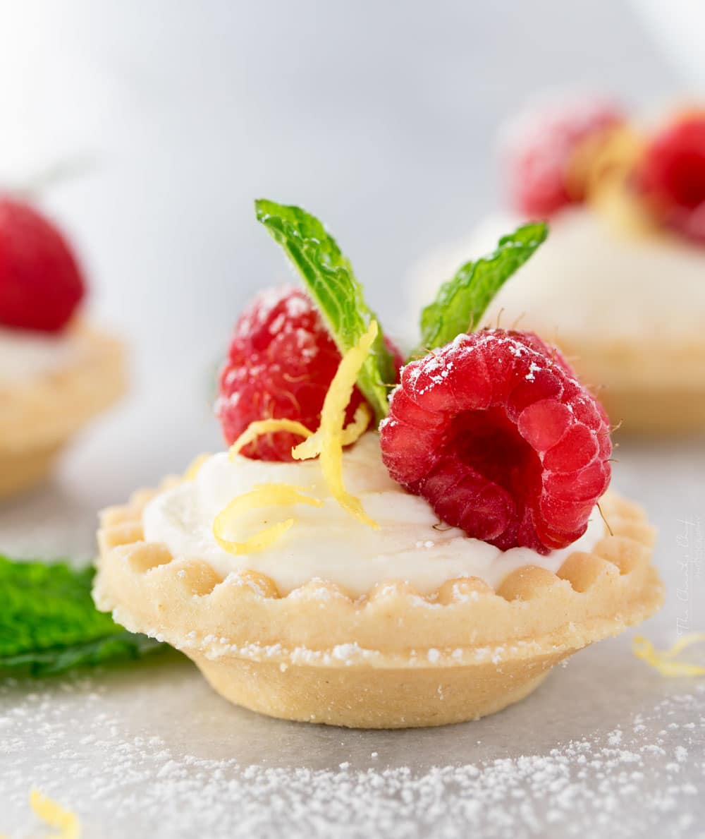 Mini No Bake White Chocolate Lemon Cheesecake Tarts | Creamy no bake white chocolate lemon cheesecake tarts, topped with your favorite fresh fruit, mint, and a dusting of powdered sugar. Impressive and easy! | http://thechunkychef.com