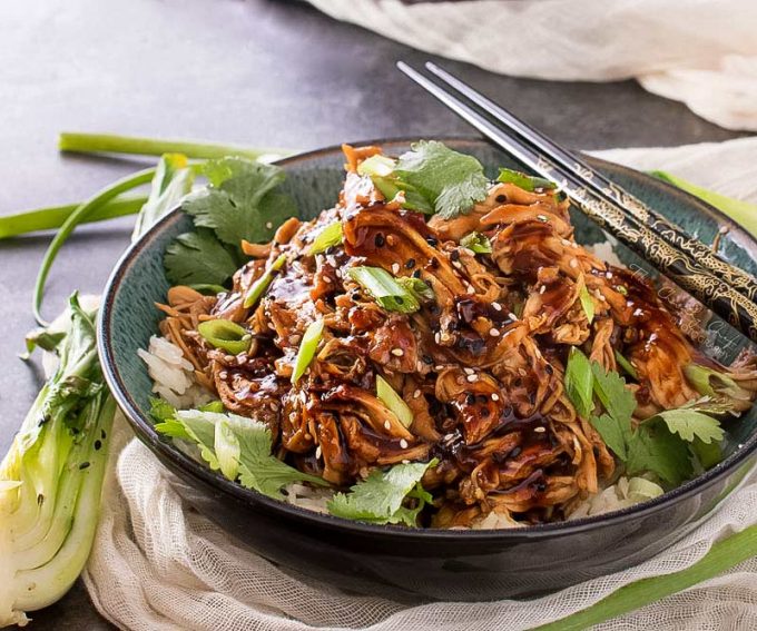 Bowl of shredded honey garlic chicken over rice