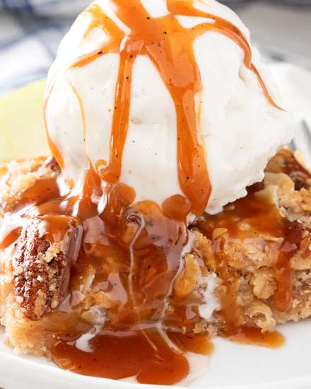 These Caramel Apple Pie Bars have all the classic flavors of a Dutch caramel apple pie, in an easy to make bar dessert form!  The cinnamon pecan streusel topping is to die for, and don't forget the browned butter caramel sauce! #applepie #falldessert #applebars #caramelapple #caramel #alamode #easydessert #dessertrecipe