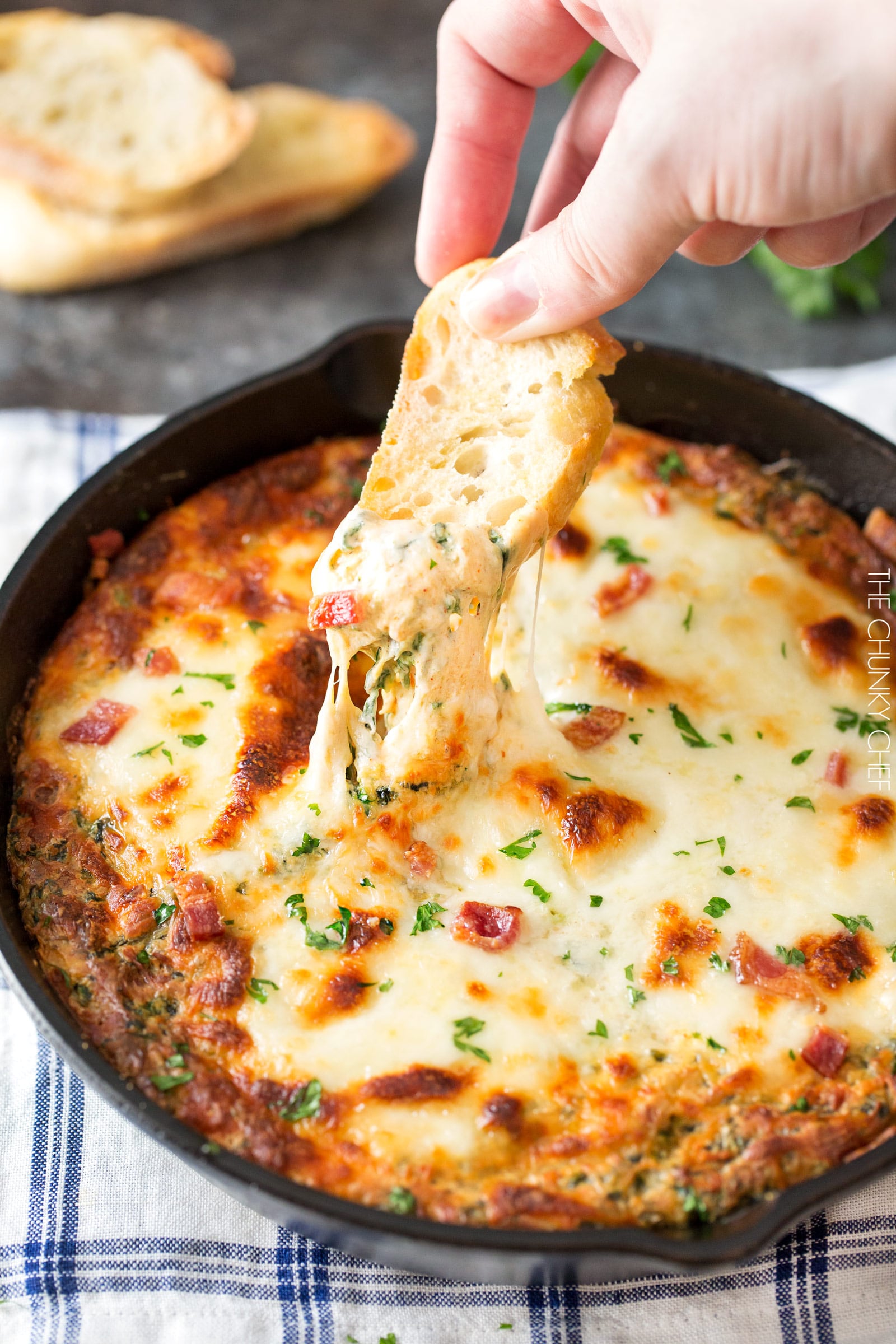 Cheesy Bacon Spinach Dip | This party spinach dip is loaded with tons of spinach, gooey cheese, crispy bacon and other mouthwatering flavors. Combine, bake, and eat! Perfect for a party! | http://thechunkychef.com