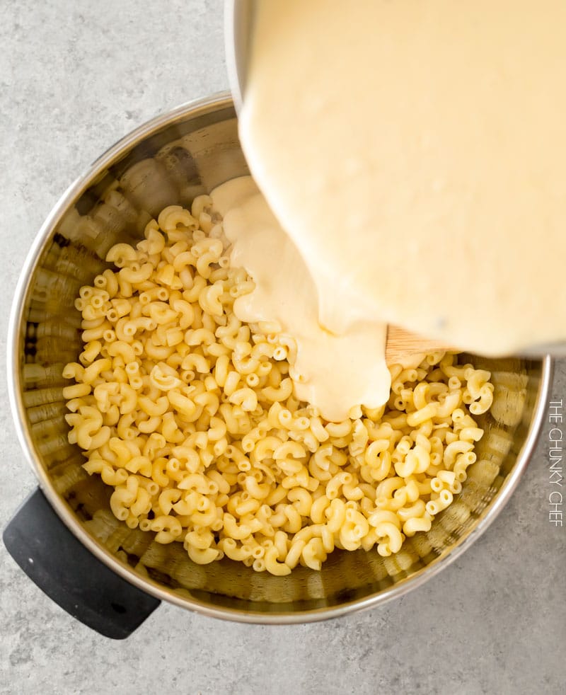 Cheese sauce pouring over pasta to make homemade Mac and cheese