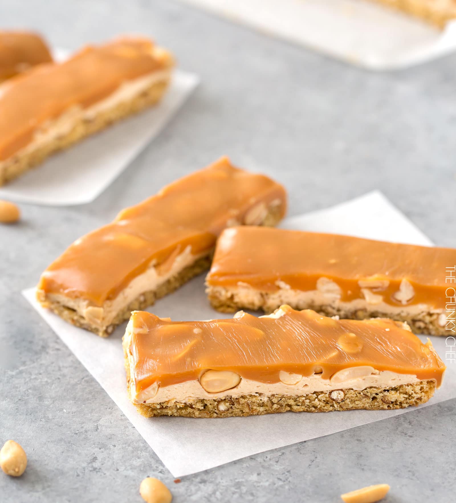 Salted Caramel Peanut Bars | These easy to make bars taste like a great candy bar! A soft pretzel flavored base is covered with a creamy nougat layer, sprinkled with peanuts, and coated in dreamy salted caramel! | http://thechunkychef.com