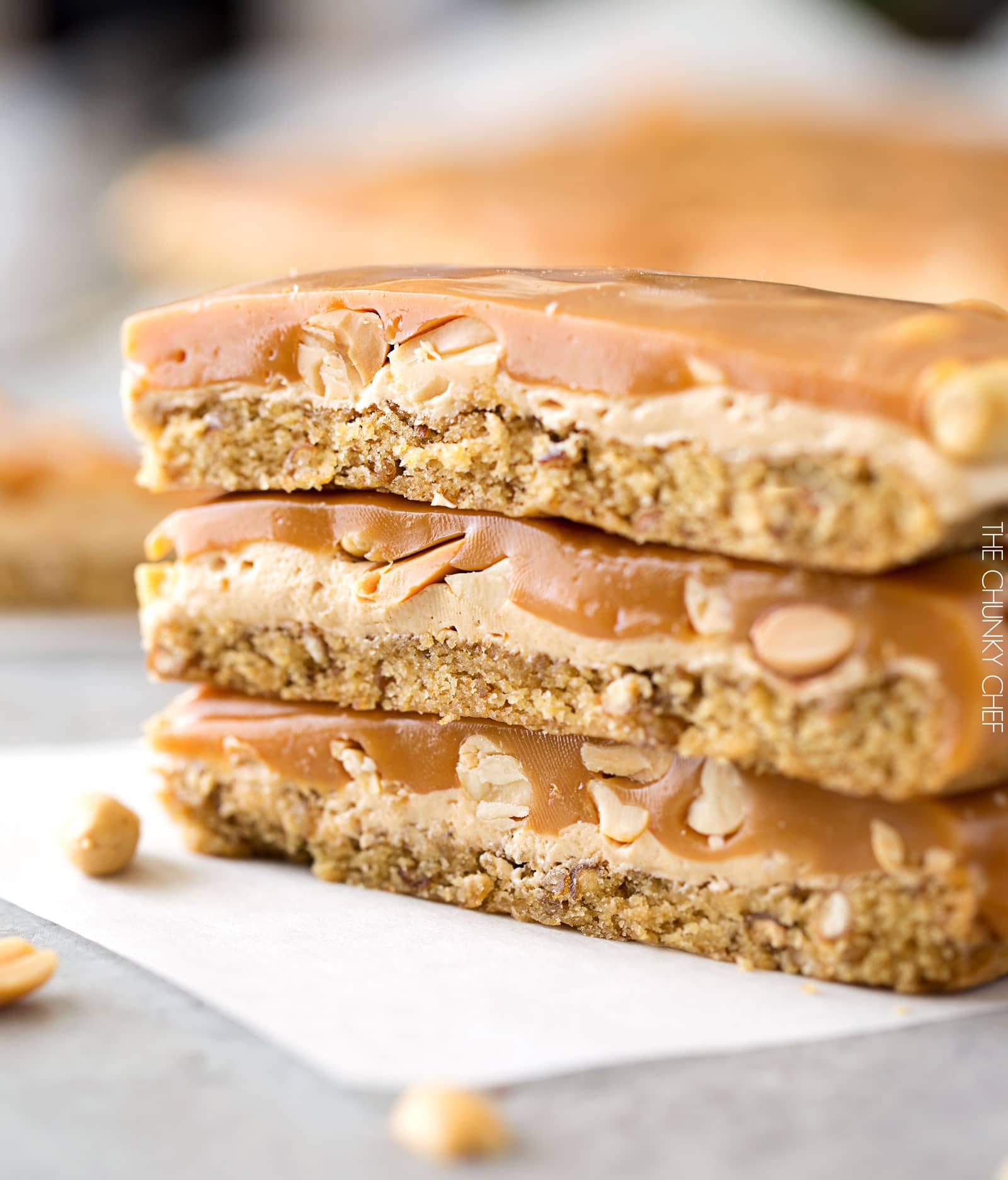 Salted Caramel Peanut Bars | These easy to make bars taste like a great candy bar! A soft pretzel flavored base is covered with a creamy nougat layer, sprinkled with peanuts, and coated in dreamy salted caramel! | http://thechunkychef.com