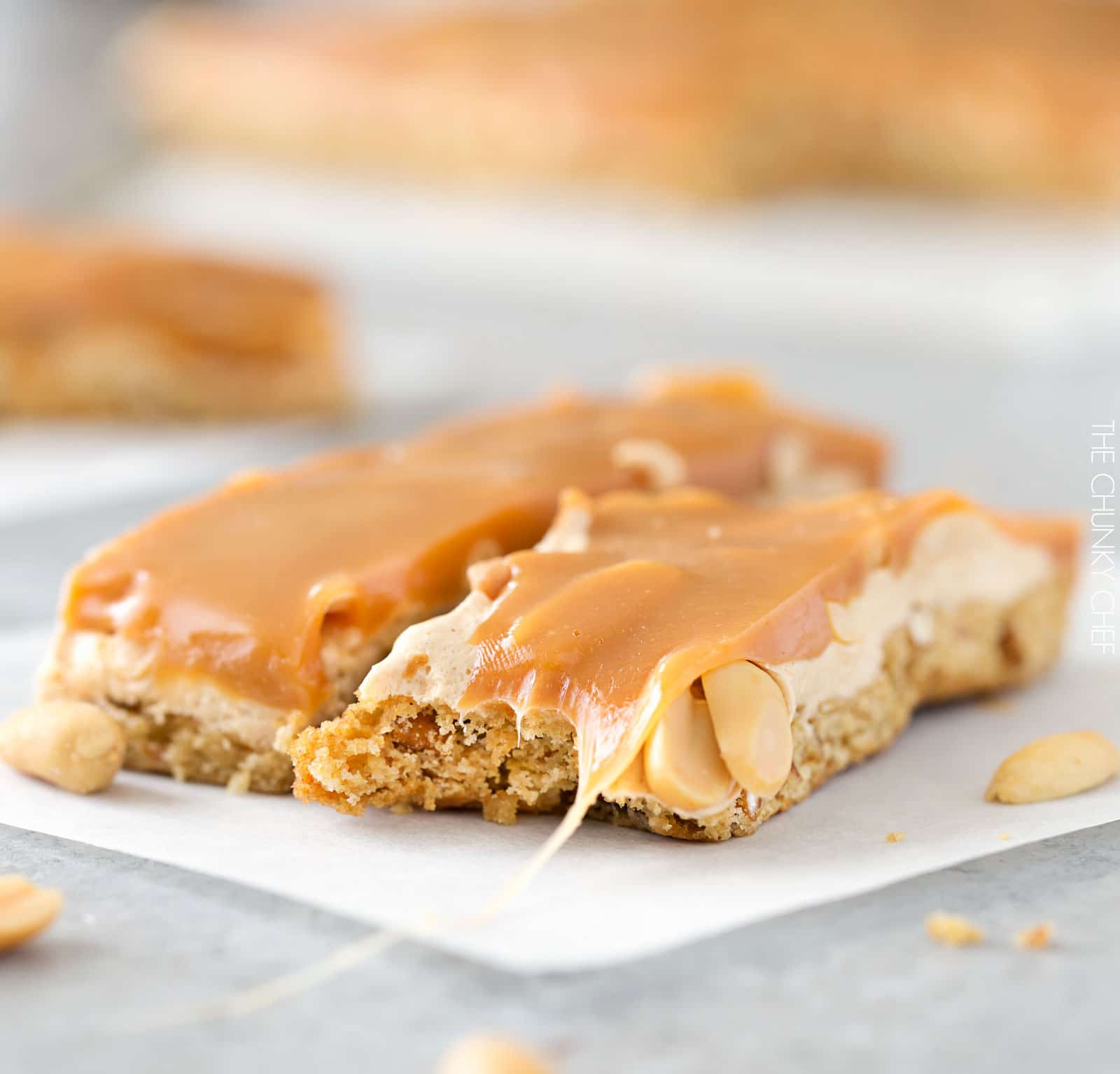 Salted Caramel Peanut Bars | These easy to make bars taste like a great candy bar! A soft pretzel flavored base is covered with a creamy nougat layer, sprinkled with peanuts, and coated in dreamy salted caramel! | http://thechunkychef.com