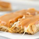 Salted Caramel Peanut Bars | These easy to make bars taste like a great candy bar! A soft pretzel flavored base is covered with a creamy nougat layer, sprinkled with peanuts, and coated in dreamy salted caramel! | http://thechunkychef.com