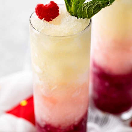 Three types of sweet wine are frozen, blended with simple syrup, and layered to create a drink that's every bit as delicious as it is beautiful! #slush #slushy #slushie #wine #ombre #valentinesday #frozendrink #mothersday #cocktail #icy
