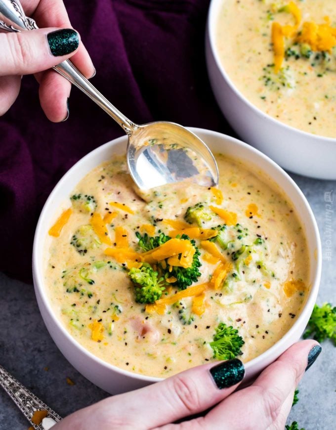 Serving broccoli cheese soup from a white bowl