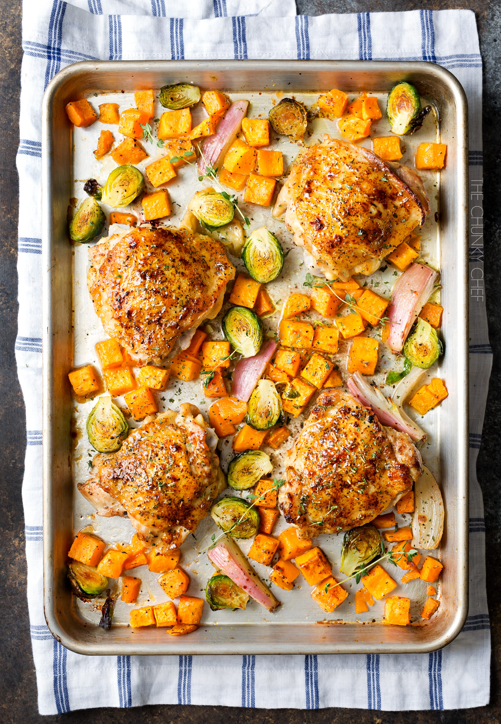 Sheet Pan Maple Mustard Roasted Chicken | Chicken thighs are coated in a sweet and savory maple mustard sauce and roasted alongside creamy butternut squash and savory brussels sprouts, all on one sheet pan for an incredibly quick, easy meal with hardly any cleanup needed! | http://thechunkychef.com