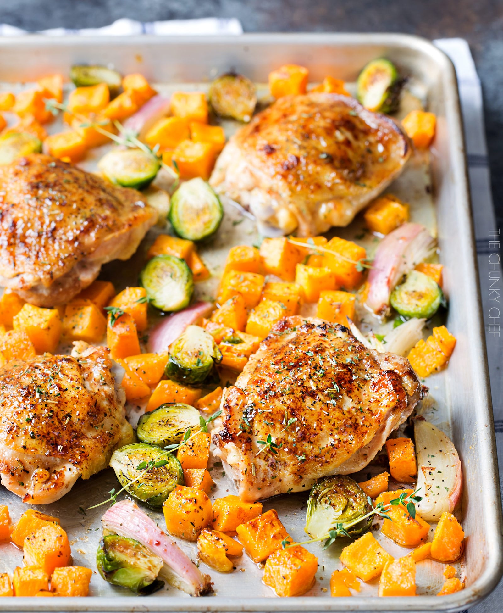 Sheet Pan Maple Mustard Roasted Chicken | Chicken thighs are coated in a sweet and savory maple mustard sauce and roasted alongside creamy butternut squash and savory brussels sprouts, all on one sheet pan for an incredibly quick, easy meal with hardly any cleanup needed! | http://thechunkychef.com