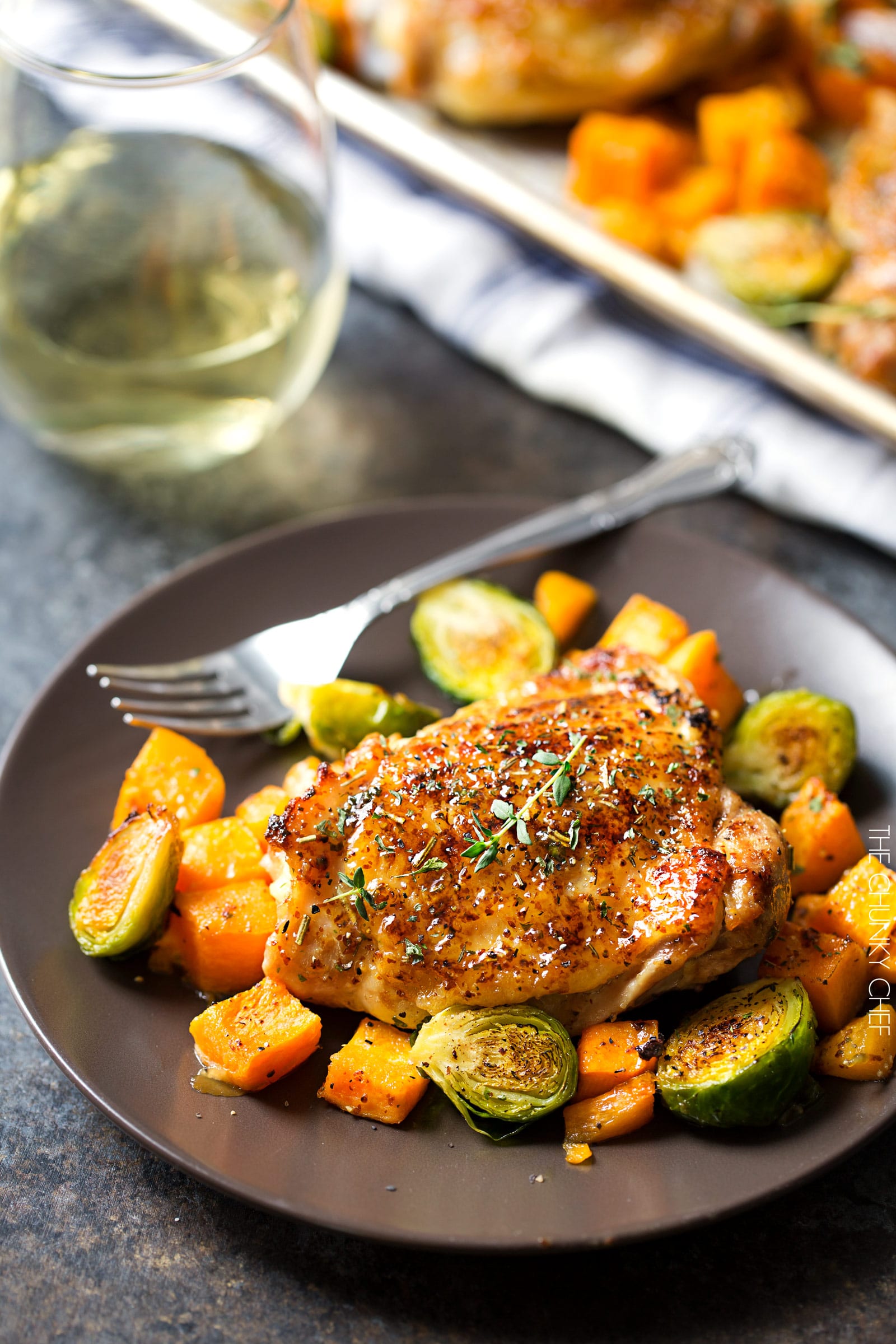 Sheet Pan Maple Mustard Roasted Chicken | Chicken thighs are coated in a sweet and savory maple mustard sauce and roasted alongside creamy butternut squash and savory brussels sprouts, all on one sheet pan for an incredibly quick, easy meal with hardly any cleanup needed! | http://thechunkychef.com