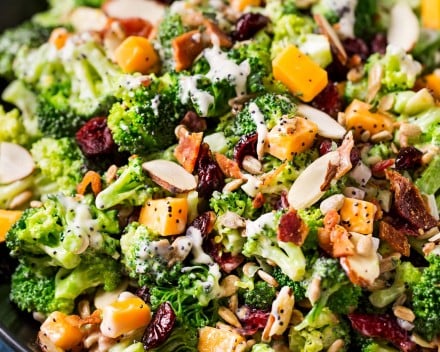 The ultimate broccoli salad is made with crunchy almonds, bacon, sunflower seeds, tart cranberries, and a creamy citrus poppyseed dressing!  Perfect make-ahead holiday side dish recipe! #sidedish #broccoli #salad #easter #memorialday #summer #easyrecipe #makeahead