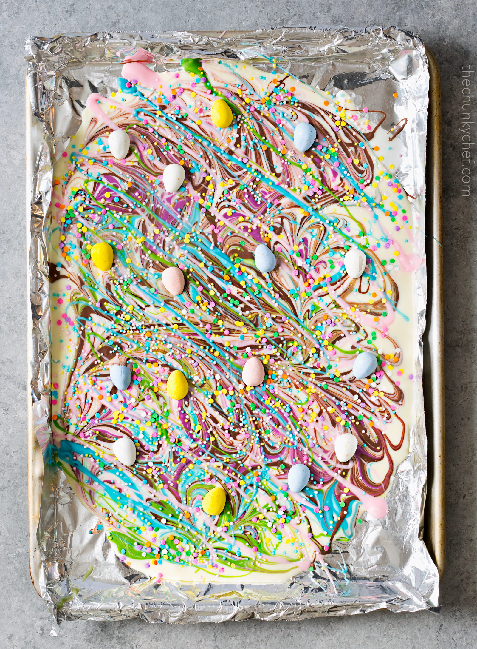 Brownie Batter White Chocolate Bark | A fun no bake bark dessert, made with white chocolate swirled together with milk chocolate brownie batter, and decorated in fun Spring colors! Easily customizable to any holiday and makes a great homemade gift! | http://thechunkychef.com